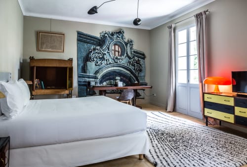 Contemporary bedroom at Mas De Lafeuillade BnB in Montpellier with white bed, ornate architectural artwork, and colorful