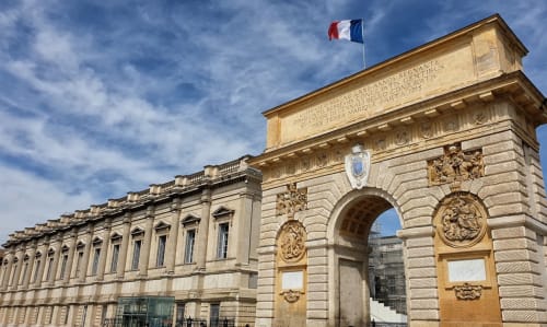 Architecture classique française avec drapeau français à Montpellier, façade élégante en pierre