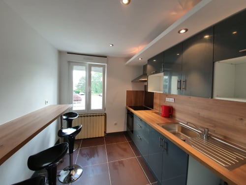 Cuisine moderne avec armoires foncées, plan de travail en bois et évier en inox à NancyRoom B&B à Vandoeuvre-les-Nancy