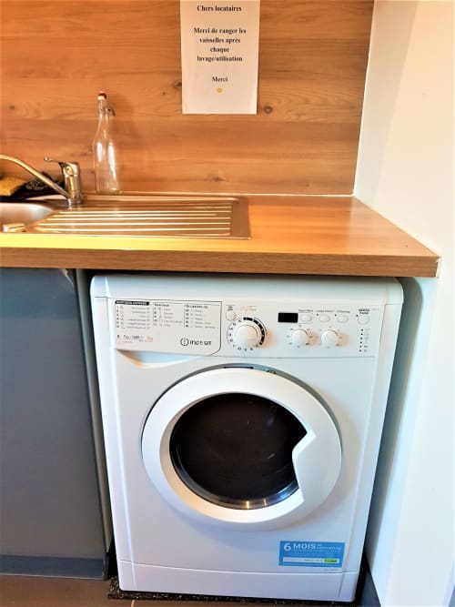 Machine à laver Indesit blanche avec plan de travail en bois, zone de laverie du NancyRoom BnB, Vandœuvre-lès-Nancy