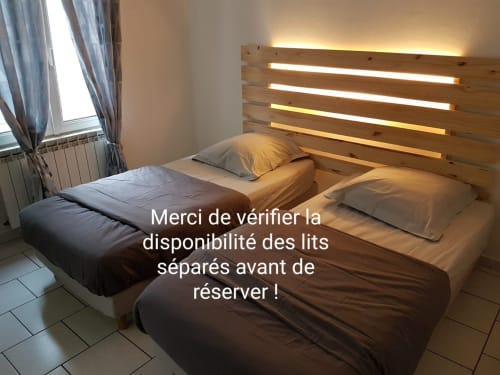 Chambre avec deux lits séparés à NancyRoom BnB à Vandoeuvre-les-Nancy, tête de lit en bois avec éclairage LED, fenêtre avec