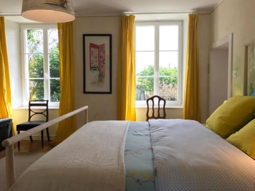 Chambre double lumineuse de L'Ermitage B&B avec rideaux jaunes, vue sur le jardin et mobilier contemporain