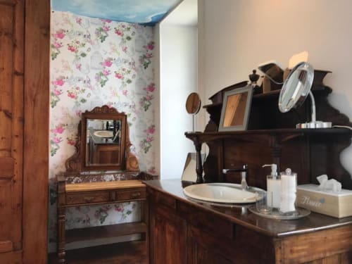 Salle de bain vintage à L'Ermitage B&B à Saint-Vaast-la-Hougue avec papier peint fleuri et mobilier en bois ancien