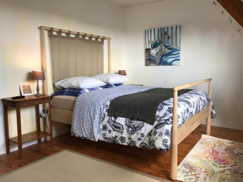Chambre double confortable à L'Ermitage B&B avec lit en bois, tête de lit rayée bleue et vue sur le jardin à Saint-Vaast-la-Hougue