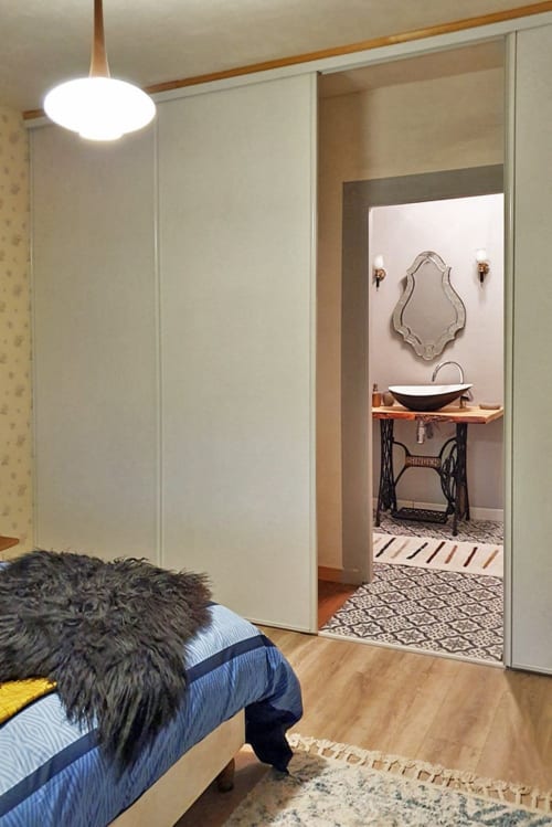 Chambre aux Forges Du Lou avec salle de bains attenante, miroir décoratif et vasque élégante