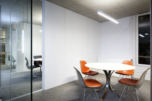 Modern meeting room at Mas De Lafeuillade with round white table, orange chairs, glass walls in Montpellier