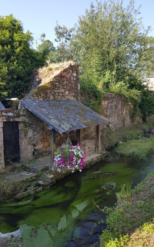 Cottage en pierre historique avec panier de fleurs près du ruisseau aux Forges du Lou, Jugon-les-Lacs