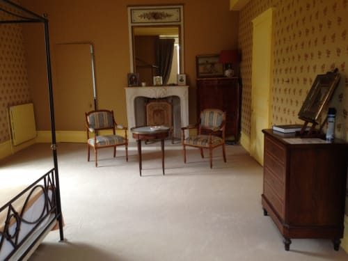 Chambre de Diane de Poitiers au Château de Ré avec mobilier d'époque, cheminée et chaises rayées