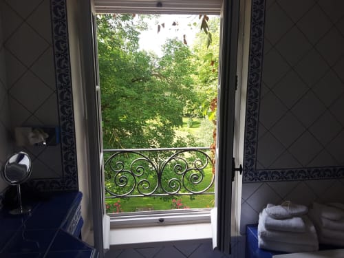 Chambre Dauphine avec portes-fenêtres donnant sur balcon orné avec vue sur le jardin luxuriant du Château de Ré, Le Petit Pressigny