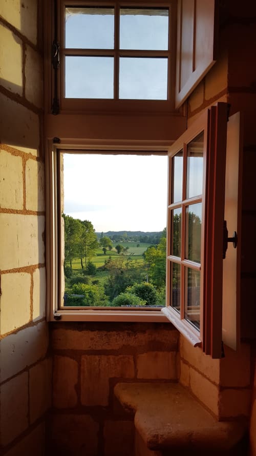Vue depuis la fenêtre de la chambre Cardinale au Château de Ré, découvrant les champs verdoyants et le paysage champêtre