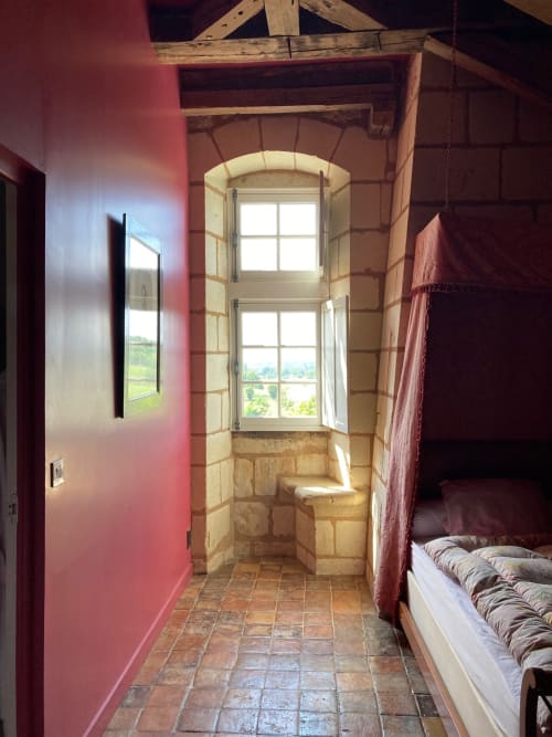Couloir des appartements Cardinale aux murs roses, sol en terre cuite, fenêtre cintrée en pierre ouvrant sur les jardins du Château de Ré
