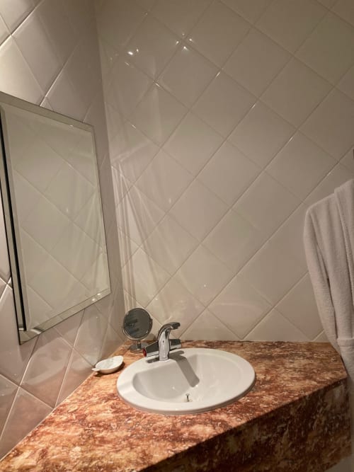 Lavabo de la chambre Cardinale au Château de Ré, Le Petit Pressigny, avec plan de travail en marbre et carrelage blanc