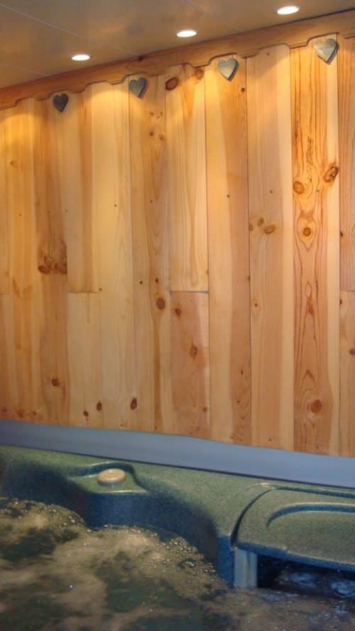 Interior de sauna de madera en L'étape Du Fanfoué, Chamrousse con detalles decorativos de corazones y zona de relajación.