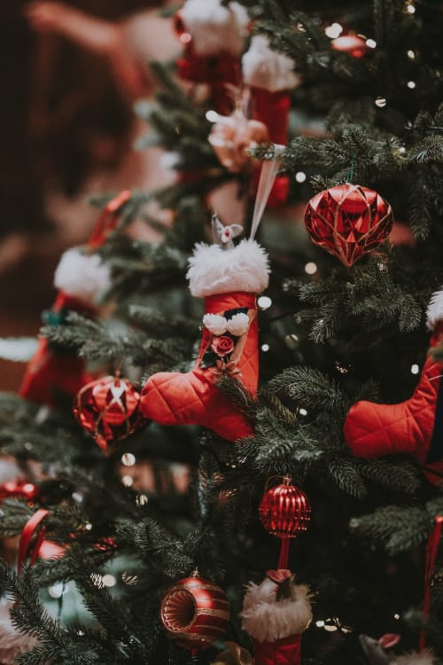 Festive Christmas tree decorated with red ornaments and white fur stockings at Chalet Domisiladoré