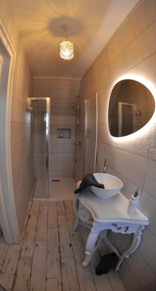 Modern bathroom at Aux Prés Du Berry B&B in Chavin, France, featuring tiled shower, illuminated mirror, and pedestal sink