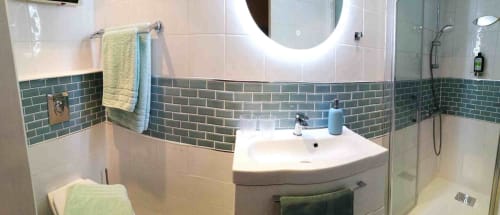 Modern bathroom with green subway tile, white sink, illuminated mirror, and walk-in shower at Aux Prés Du Berry B&B, Chavin,