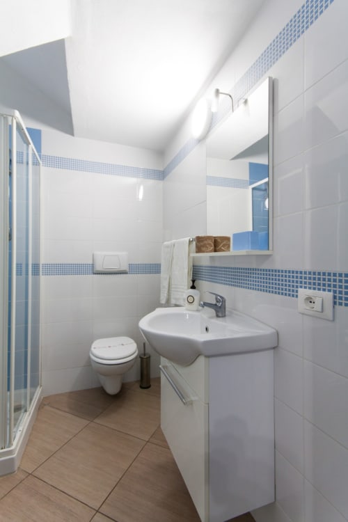 Modern bathroom in Studio Blu at Casa Vacanze Del Golfo, Castellammare del Golfo, featuring white tiles with blue mosaic