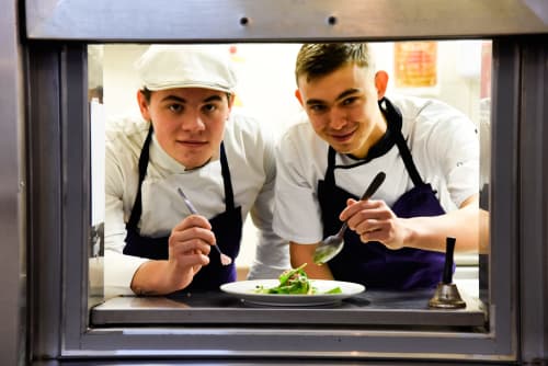 Two chefs plating a gourmet dish at Mas De Lafeuillade, a boutique bed and breakfast in Montpellier, France.