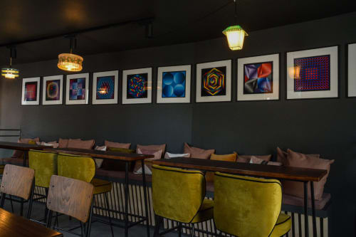 Modern lounge seating with lime chairs at Mas De Lafeuillade boutique hotel in Montpellier, colorful artwork displayed above