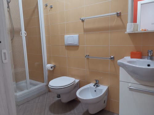 Modern bathroom in Apartment Orange at Casa Vacanze Del Golfo with toilet, bidet, sink, and glass shower enclosure