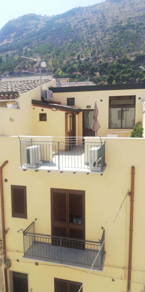 Villa gialla mediterranea con balconate affacciate su montagne boscose, Casa Vacanze Del Golfo a Castellammare del Golfo