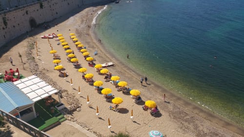 Beach at Casa Vacanze Del Golfo in Castellammare del Golfo with yellow umbrellas and clear turquoise waters