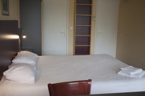 Chambre d'hôtel au Mape Hotel à Dampierre en Burly avec lit double, draps blancs, bureau et équipements modernes