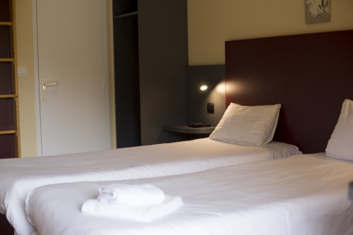 Chambre moderne de l'hôtel Mape avec deux lits jumeaux, tête de lit bourgogne et design contemporain à Dampierre en Burly