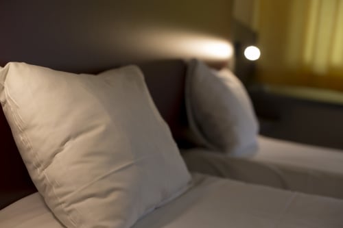 Oreillers confortables sur un lit à l'Hôtel Mape à Dampierre en Burly avec éclairage chaleureux et vue sur le jardin