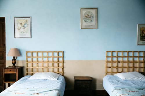 Deux lits jumeaux aux têtes de lit en bois dans la Chambre Bleue de La Vieille Foulonnière, un gîte à Pontorson, France, aux teintes bleu clair