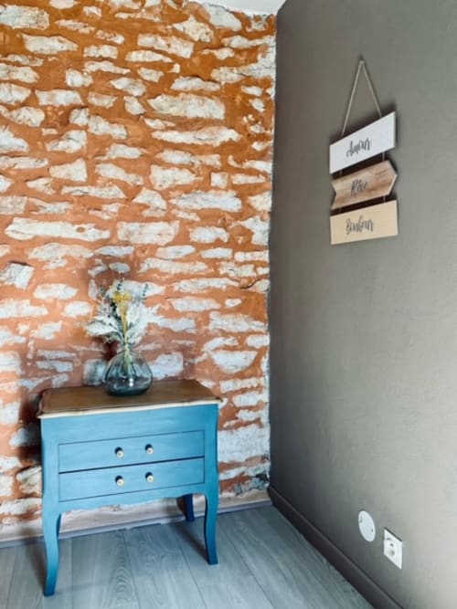 Bohème-Zimmer im La Maison de la Colline: freiliegende Backsteinwand, blauer Nachttisch mit Holzplatte und Farbkonzept
