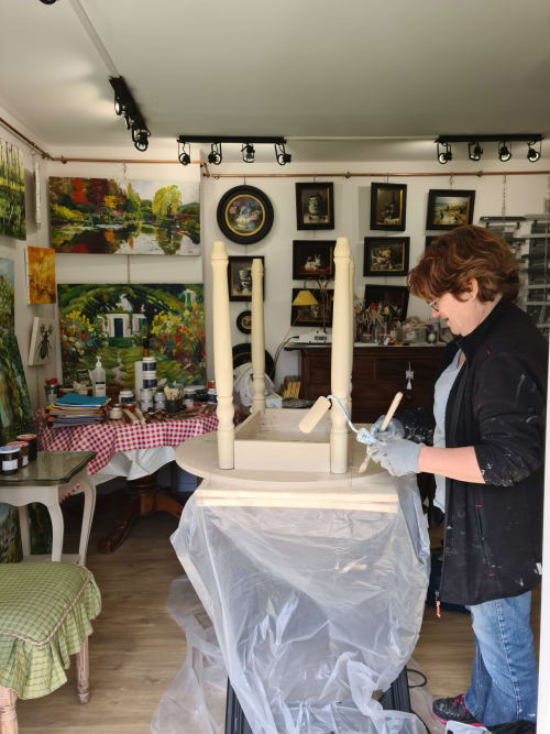 Femme déballant ses affaires à la maison d'hôtes Le Petit Nid d'Aigle à Giverny, studio artistique rempli de tableaux et de décor