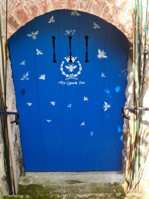 Porte bleu vif numérotée N°7 ornée de motifs d'abeilles au gîte Le Petit Nid d'Aigle à Giverny, France