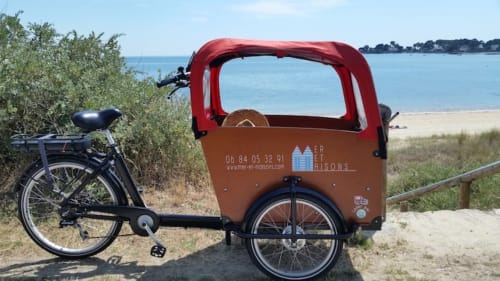 Vélo-cargo électrique à auvent rouge à l'hôtel Mer et Maisons de La Trinité-sur-Mer, France