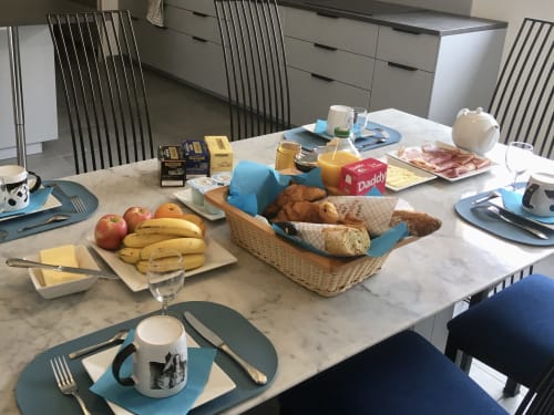 Table de petit-déjeuner élégante au Domaine Des Bois Argentés avec fruits frais, pâtisseries et couverts
