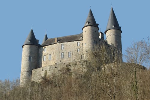 Tour de château médiéval de l'hôtel Le Moulin Des Ramiers à Crupet, Belgique, avec toits coniques et fortifications en pierre
