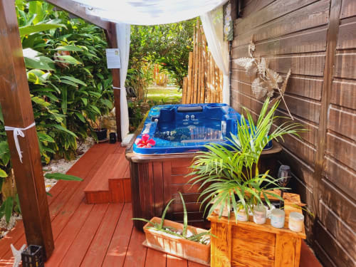 Private hot tub on wooden deck surrounded by tropical plants at Gites Kaladja, Port-Louis Guadeloupe