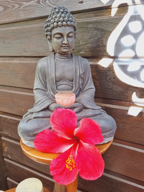 Buddha statue with red hibiscus flower at Gites Kaladja, Port-Louis Guadeloupe bed and breakfast
