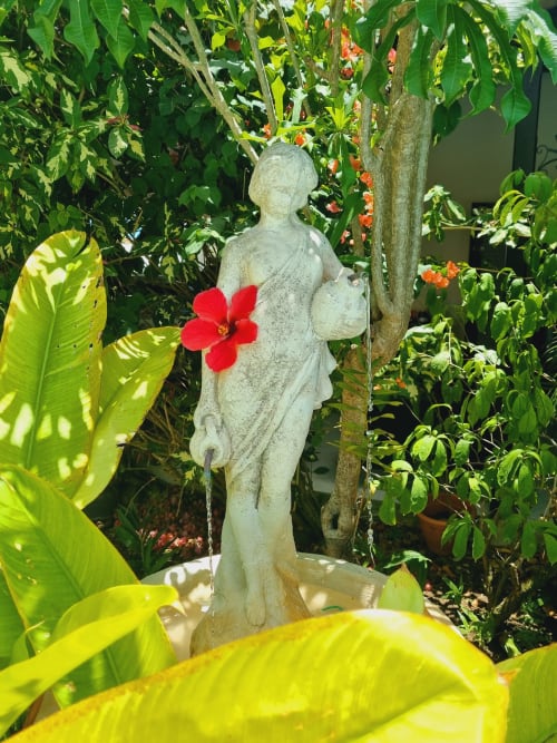 Stone garden statue with red flower at Gites Kaladja guesthouse, Port-Louis, Guadeloupe