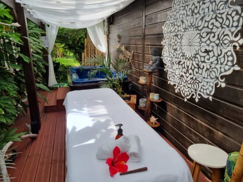 Outdoor spa massage table with red flowers at Gites Kaladja boutique hotel in Port-Louis, Guadeloupe