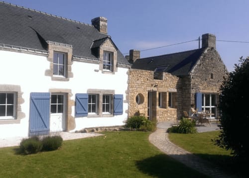 Hôtel Mer et Maisons à La Trinité sur Mer : petites maisons blanches et en pierre avec volets bleus, pelouse impeccable et terrasse.