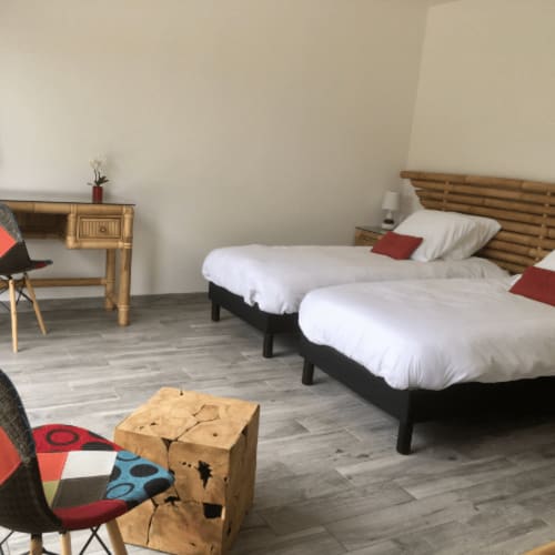 Chambre twin avec têtes de lit en bois, linge blanc et accents rouges au Domaine Des Bois Argentés B&B à Pruniers-en-Sologne