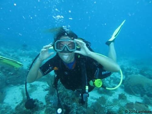 Plongeur en scaphandre autonome dans l'eau bleue avec équipement de snorkeling, expérience de plongée à Port-Louis Guadeloupe