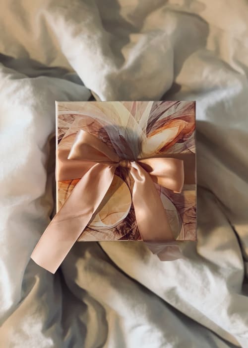 Élégante boîte-cadeau avec ruban pêche sur tulle blanc au Domaine Des Bois Argentés