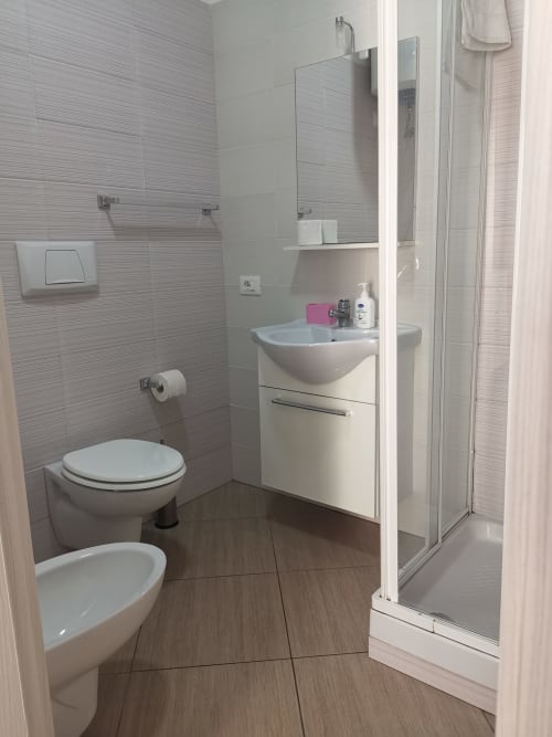 Modern bathroom with white sink, toilet, and glass shower enclosure at Casa Vacanze Del Golfo apartment in Castellammare del
