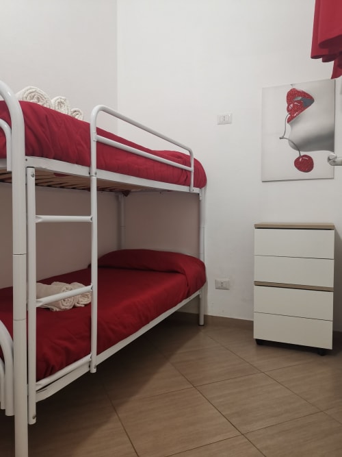 Bunk bed with red bedding in modern apartment at Casa Vacanze Del Golfo, Castellammare del Golfo