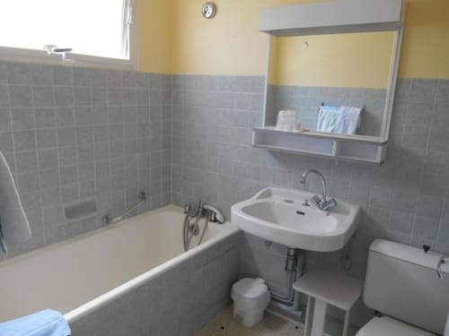 Salle de bain de A L'Abri Des Vents à Saint-Jean-le-Thomas avec baignoire, lavabo et toilettes