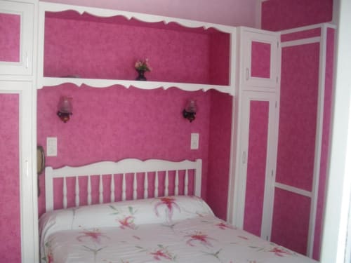 Chambre rose vif avec boiseries blanches et rangements intégrés à L'Abri Des Vents, Saint-Jean-le-Thomas