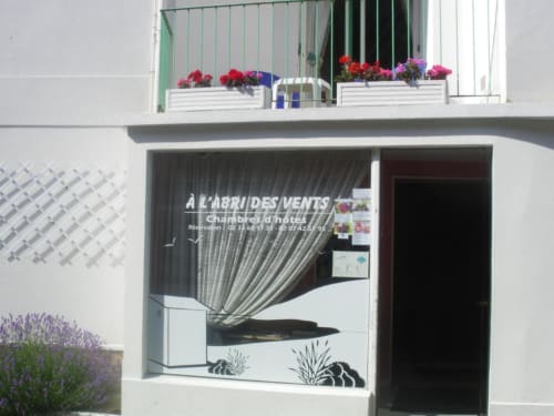 La devanture de la maison d'hôtes L'Abri Des Vents à Saint-Jean-le-Thomas avec des fleurs au balcon