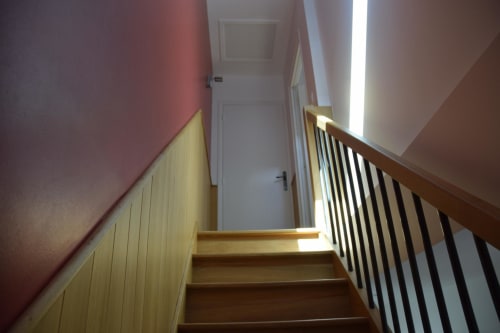 Escalier en bois et murs roses à la gîte Le Fassardy à Châteauroux, France